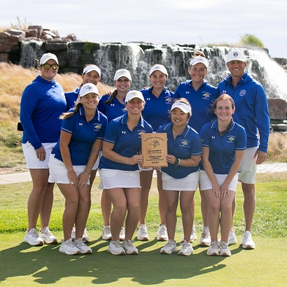 SDSU women's golf team stand together holding a trophy.