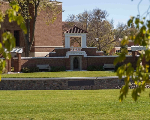 Sylvan Theatre on a beautiful summer day framed by green leaves.