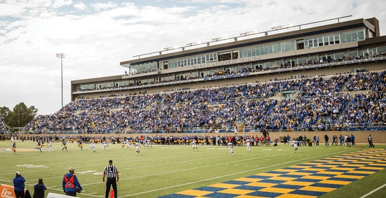 An SDSU Football game at the Dana J. Dykhouse Stadium with a packed stand. Fans are wearing blue and yellow.