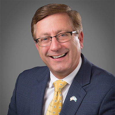 A professional headshot photo of Mike Huether.