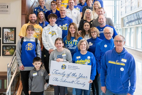 2024 Family of the Year smiles together on a set of stairs
