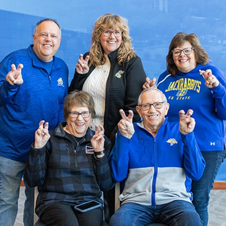 David and Elaine Gullickson with their three kids, all doing the "ears up" gesture