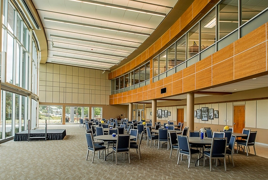 a photo of Woster Celebration Hall inside of the SDSU Alumni Center, set up with tables and chairs and a small stage