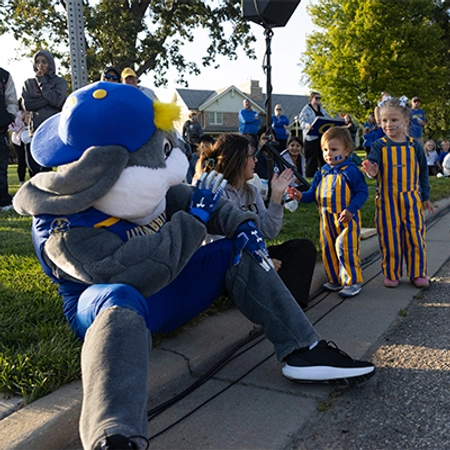 Jacks waves at two little kids during the Yellow & Blue Block Party.