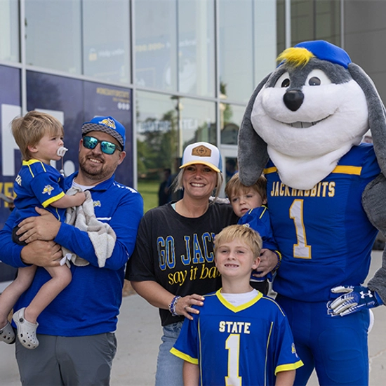 Jack smiles with a family during the Yellow & Blue Block Party.
