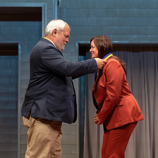 College dean places a medallion around the neck of a newly endowed holder.