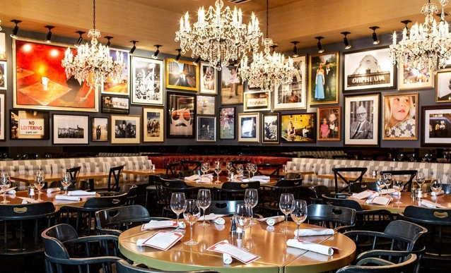 Interior view of the Arrogant Butcher in Phoenix, AZ, with photos all over the wall and beautiful chandeliers.