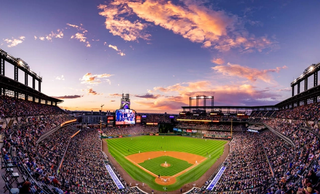 A beautiful sunset over a full Coors Field Stadium during a Rockies baseball game.