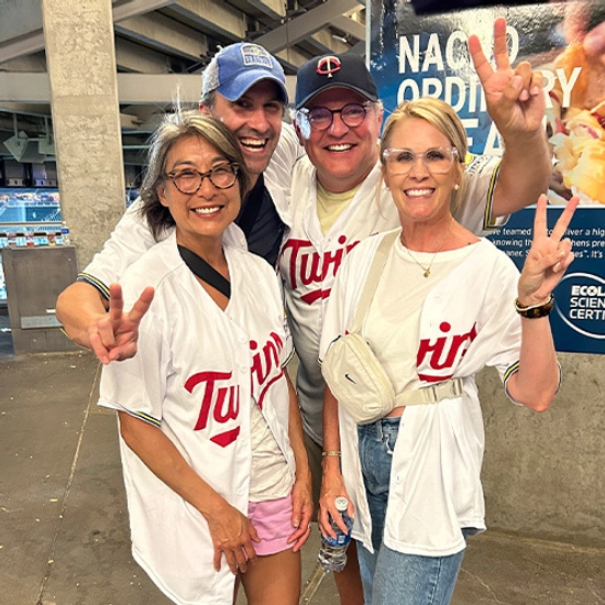 A group of people at a Minnesota Twins' game wearing Twins jerseys.
