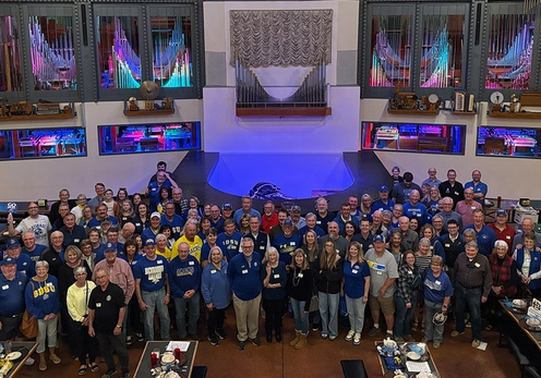 A large group of SDSU alumni, friends, and families at Organ Stop Pizza in Arizona, standing and smiling for the camera.