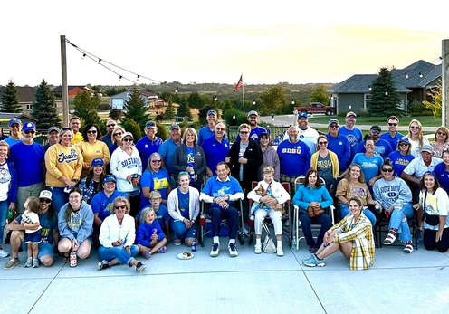 A large group of SDSU alumni, friends, and families smiling outdoors at a Yankton Area Jacks chapter gathering.
