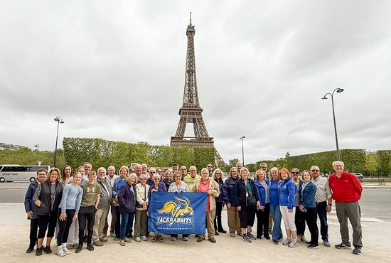 Large group traveling with Jackrabbit Journeys in front of the Eiffel Tower