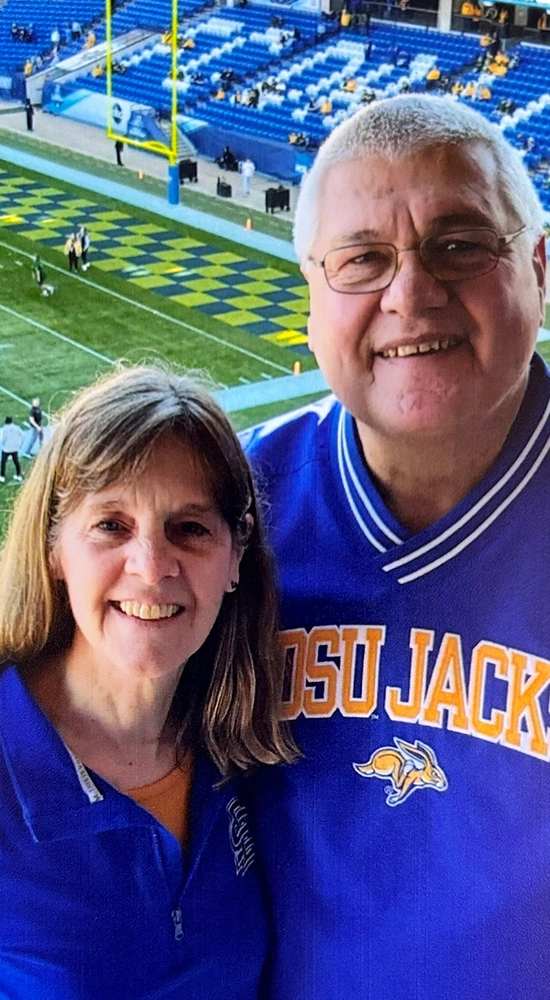 A couple in jackrabbit gear at a football stadium