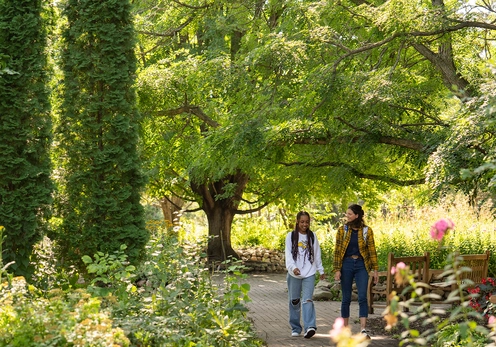Two female students walking on a path in McCrory Gardens