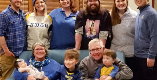 coach stig and his family smile in a living room