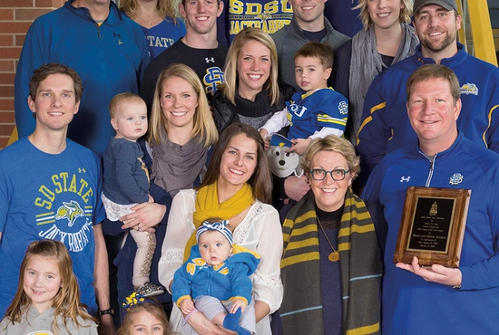 Group photo of the Brian and Denise Aamlid family, all dressed in yellow and blue, from when they were recognized as the SDSU Family of the Year in 2016.
