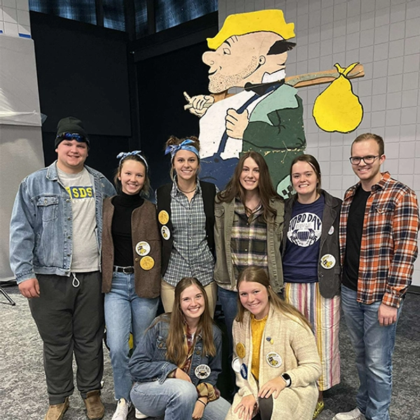 Abby smiles with a group of other SDSU students during the Bum-a-Meal Hobo Day event