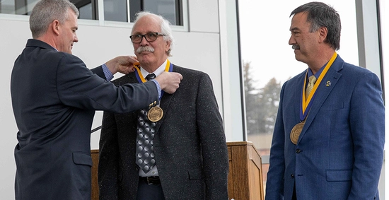 Dr Clay having his medallion placed around his neck