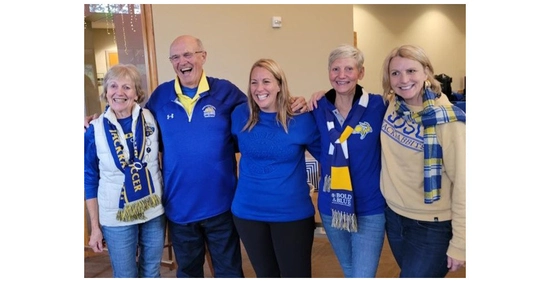 Rae Jean and Dan Gee standing and smiling with their three daughters, all dressed in Jackrabbit attire.
