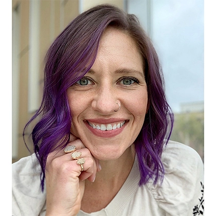 Close up shot of Anne Karabon smiling at the camera.
