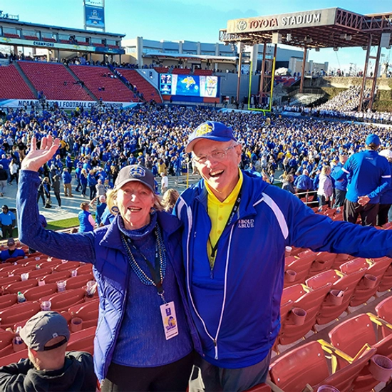 the Gees celebrate with their hands in the air after the fcs championship game with a huge crowd on the field in the background