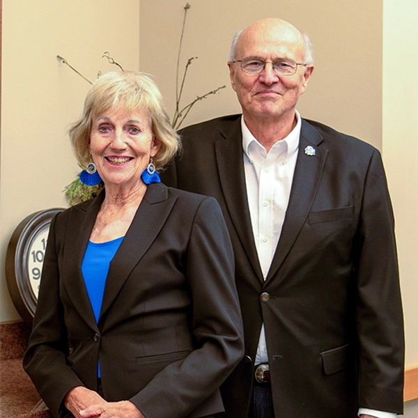 The Gees stand next to one another smiling, wearing fancy clothing