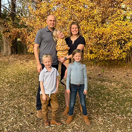 Erin Glidden and her husband Tyler with their three kids with a fall scenic background