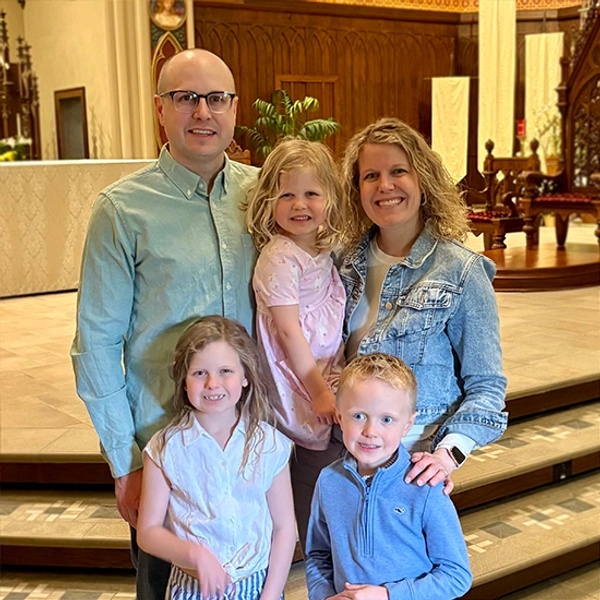 Erin Glidden and her husband Tyler smile with their three kids