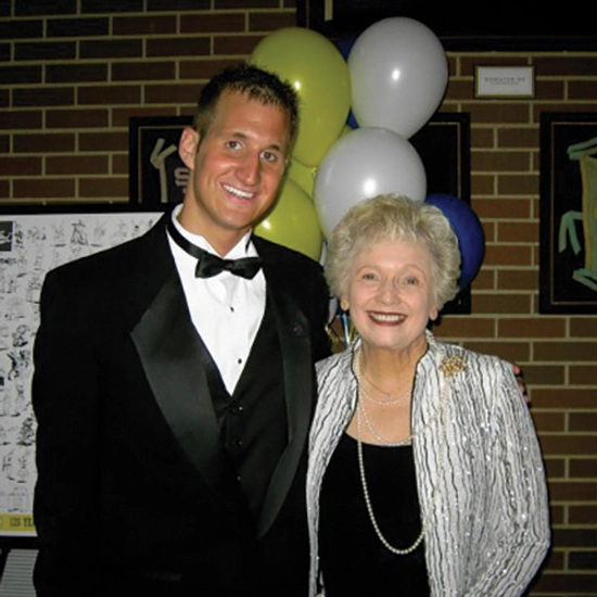 alex halbach smiles with president emeritus peggy miller, both dressed in family clothes, when he was a student
