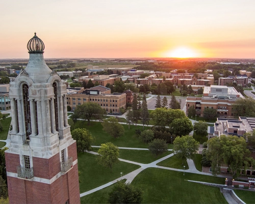 Aerial photo of the Coughlin Campanile at sunrise with campus in the background