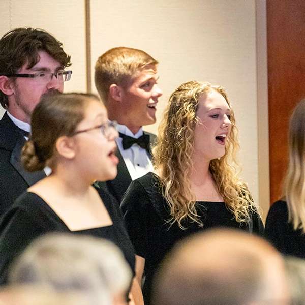 4 students are pictured singing in the choir