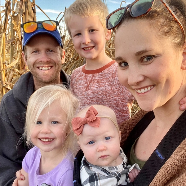 Jenna and her husband and three children in a cornfield