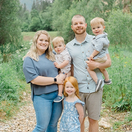 Jillian Baldini posing with her family consisting of her husband and three children