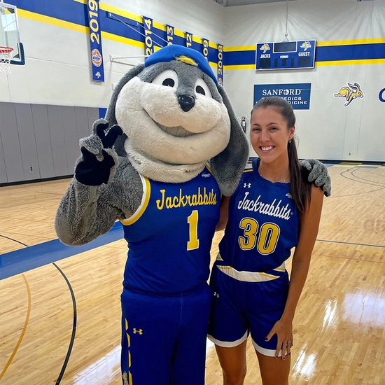 Jordan in her SDSU basketball uniform with Jack the Jackrabbit