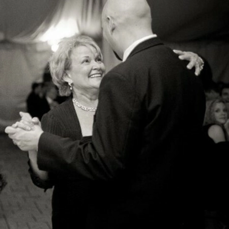 couple dancing, with the woman smiling up at the man