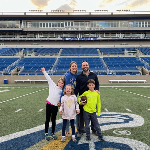 Rachel and her family stand on the 50 yard line of the Dana J Dykhouse Stadium at South Dakota State University