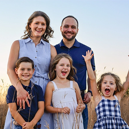 Rachel smiles with her husband and three kids.