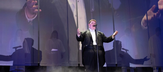 steiger sings a solo in a tuxedo, with his arms stretched open wide