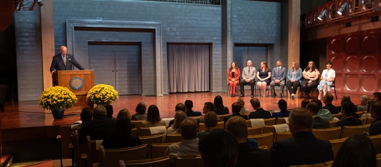 Photo of the stage and crowd at the University Leadership Honors ceremony, with Provost at the podium and the honorees sitting on stage