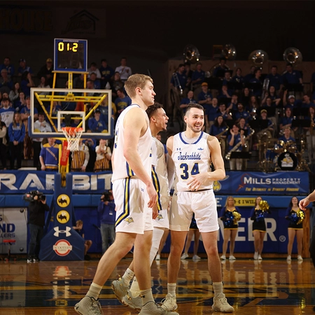 mens basketball players stand together during a game