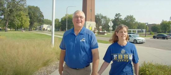 A couple in jacks gear walking on campus