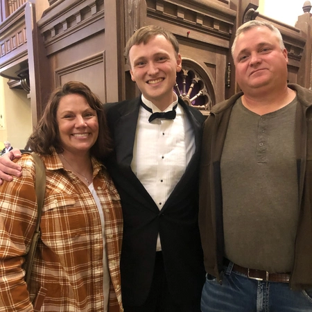 SDSU male choir members with his parents next to him, smiling
