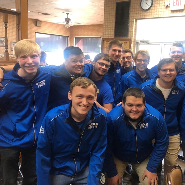 Group of sdsu choir members smiling and arm in arm