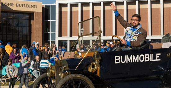 2022 Grand Pooba, Regen Wiederrich, waves to the crowd while driving the Bummobile during the parade