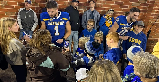 Janke twins after an sdsu football game, signing autographs for young fans and taking photos with them