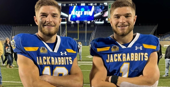 Janke twins stand side by side with arms crossed on the dana j dykhouse field after an sdsu football team win