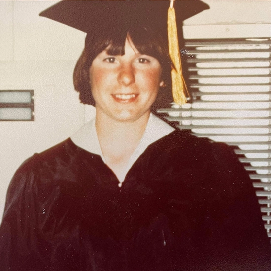Cheryl in graduation cap and gown from years ago