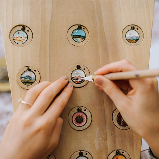 close up of grace's hands sculpting one of the early clay necklaces