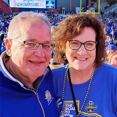 Steve Erpenbach and his wife smile after the football team wins the championship game in Frisco, TX
