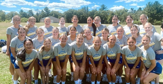 group of sdsu cheerleaders smiling at a camp all in matching grey shirts and blue shorts
